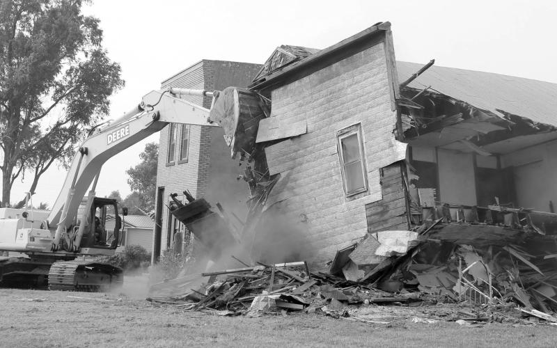 Trail City Take Down ... Part of Trail City’s history was turned to dust last Wednesday, Sept. 11, when the former Post Office and pool hall were leveled. Contracted to do the tear down was Jim and Bucky Bartlett and Beamon Kraft from Bartlett Ag Supply. Photo by Jon Flatland