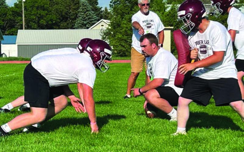 Dan Porisch (kneeling right), starting center for the Northern State University Wolves, runs players through drills at a football camp hosted by two local NSU players - Hank Kraft of Timber Lake and Brady Bauer of Mobridge-Pollock.