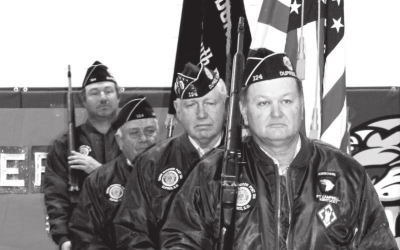 The American Legion Post 124 Dupree Honor Guard posting colors at the Dupree School Veterans Day Program. (FRONT-BACK): Ramon Birkeland, John D. Lemke, Gary Birkeland, and Leo Bakeberg III.