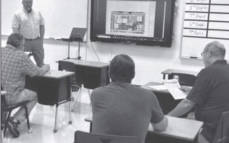 John Paul, standing, of Johnson Controls, fields questions from Timber Lake School officials last Wednesday, Aug. 23, while discussing a $1.8 million HVAC improvement project the board approved later in the evening. Photo by Jon Flatland
