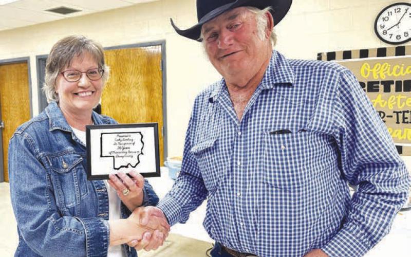 Cathy Lemburg received a plaque from Dewey County Commission Chairman Bob Berndt at a retirement party in her honor on June 19. She also received a star quilt from county employees presented by Highway Supt. Will Wiedmer.