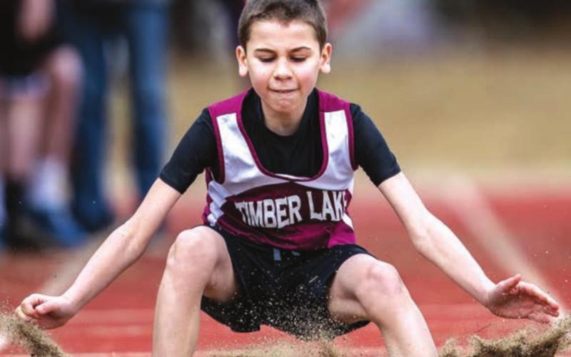 Braden Lawrence touches down in the sand pit after a long jump try. He placed 4th in the junior high conference meet.