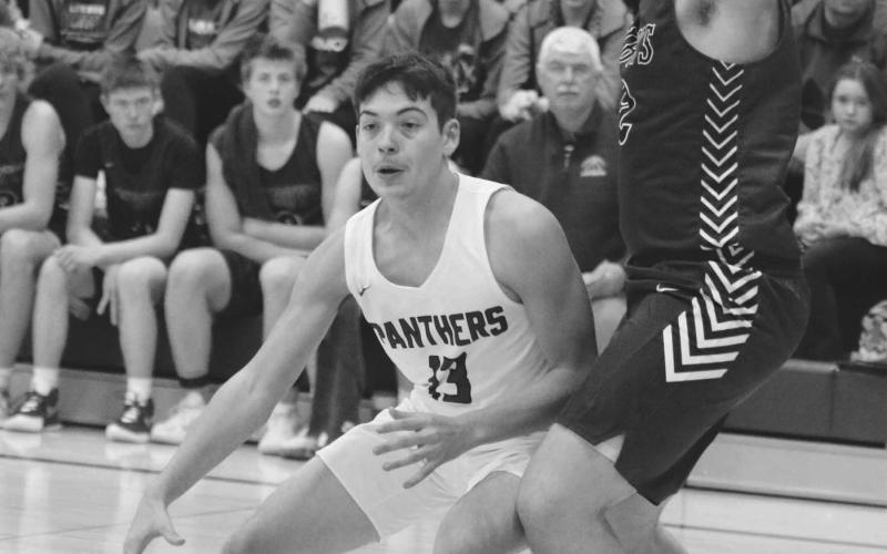 Junior forward Aidan Rough Surface dribbles into the paint while being defended by Ethan Nehl of Lemmon during LMC boys basketball action in Timber Lake last Friday, Dec. 9. Photo by Jon Flatland