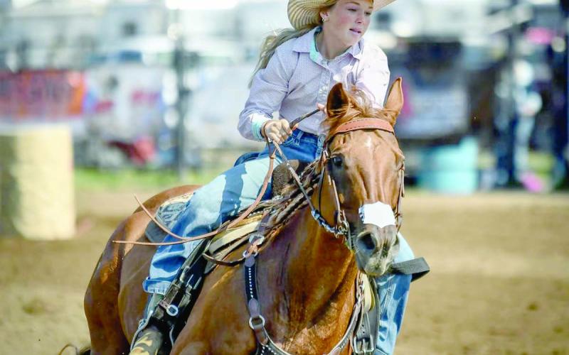 Korbi Heck, left, runs her horse through the Sr. Barrels at the State 4-H Finals Rodeo. She placed eighth overall in the event to wrap up a successful season.