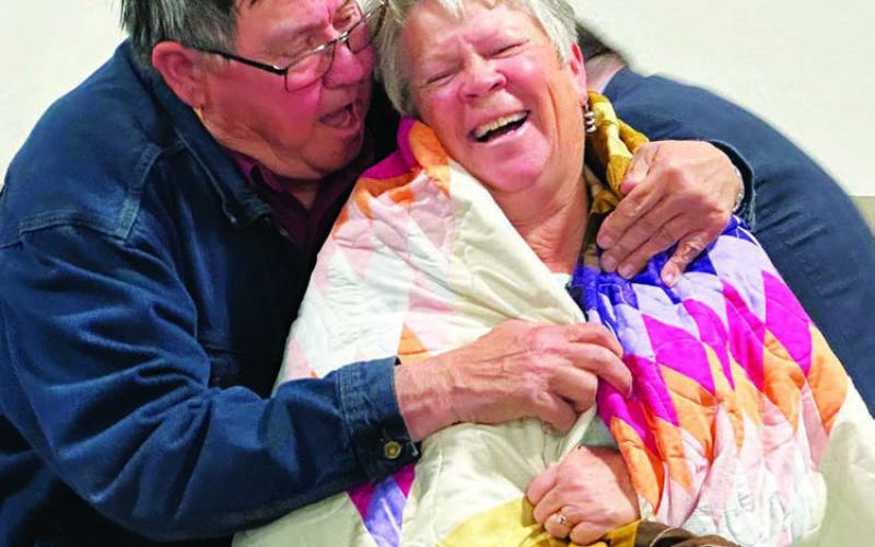 Board member Paul Lawrence presents out-going MGEC Manager Melissa Maher with a star quilt during the cooperative’s 78th annual meeting last Wednesday, Oct. 9. Photo by Kathy Nelson
