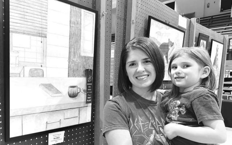 Ali Eigelaar and her daughter Thea with Ali’s blue ribbon drawing at the Mobridge Art Show.