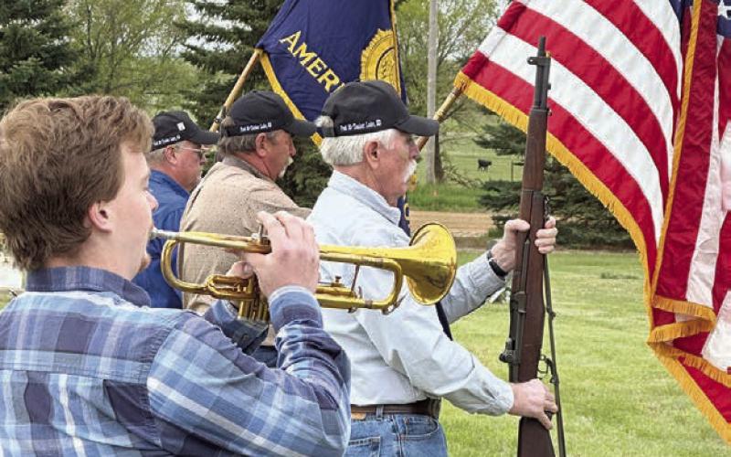 Caleb Quinn played TAPS at the Timber Lake Cemetery as part of the Memorial Day program on May 26. Veterans who fired a salute over teh grave of Patrick Quinn are (l-r) Ken Quinn (Legion Post 83 Commander), Roger Hieb, and Jack Bickel. Photo by Kathy Nelson