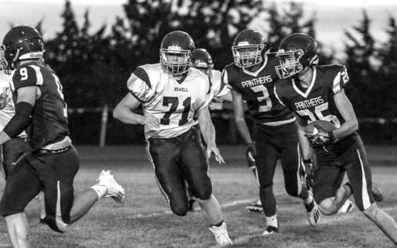 Timber Lake senior Hunter Schrempp (26) runs with the ball as teammates Hank Kraft (9) and Chazz Gabe (3) look to block during their home victory over Newell on Friday. Photos by Jon Flatland