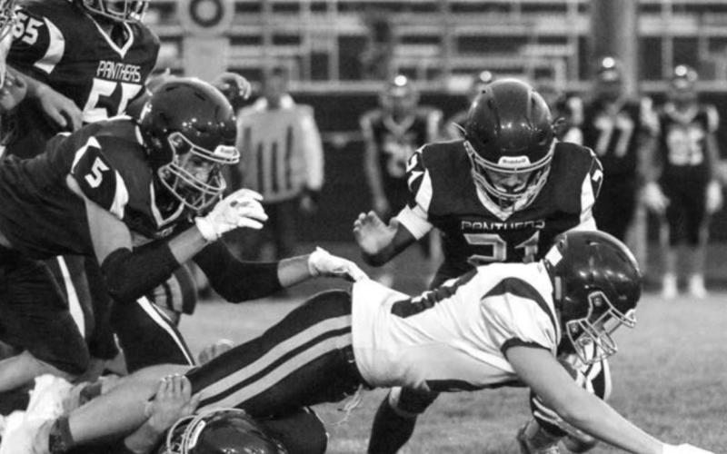 Timber Lake’s Caleb Quinn (21) jumps on a Newell ball carrier as Hank Kraft wraps up his legs with Trenton Hansen (5) and AJ Lindskov (55) moving in.