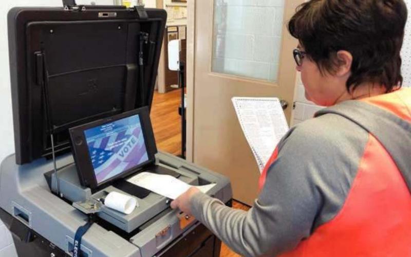Deputy Dewey County Auditor Cherie Leibel does a test run of ballot tabulating equipment on October 23 in preparation for the November 3 general election. The machine scans and counts the votes on the paper ballots and prints out a ticket to verify the count.