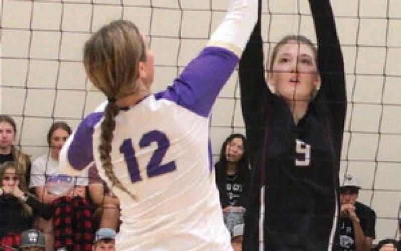 Senior Sara Holzer (9) attempts to block a spike by Harding County’s Jaelyn Wendt (12) in the volleyball season opener last Thursday, Aug. 24. Photo by Jon Flatland