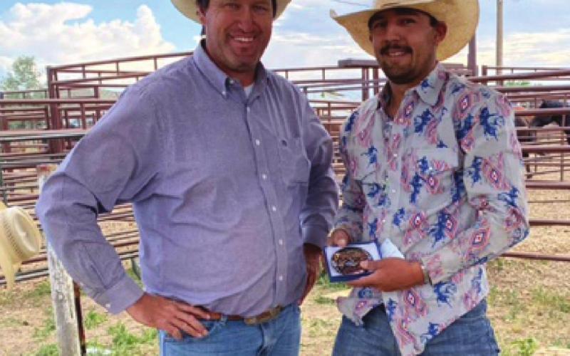 Nate Greub, left, president of the Dupree Rodeo Committee, presents Wild Ride winner Seth Longbrake of Milesville with the 2021 gold buckle. Longbrake also finished third overall in the saddle bronc competition during the Pioneer Days Rodeo on Saturday and Sunday. Courtesy photo