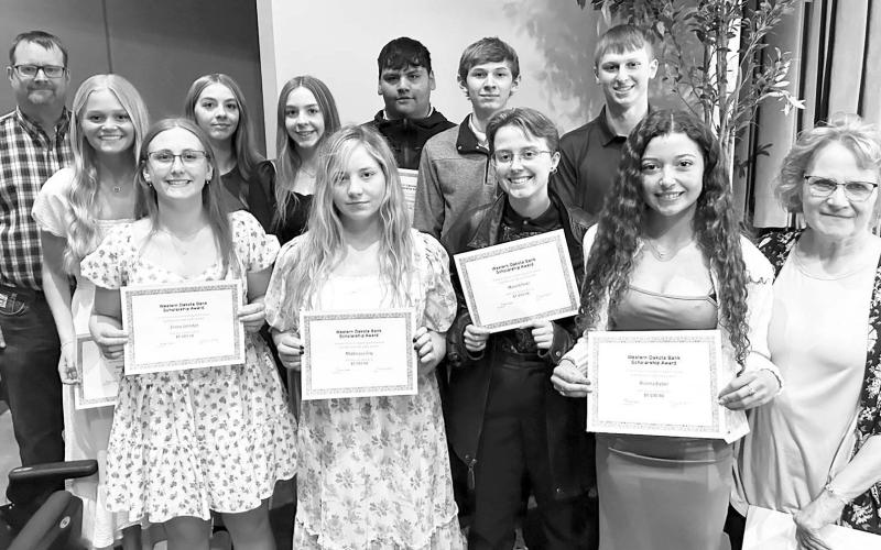 Western Dakota Bank awarded $1000 scholarships to 12 students. The 10 from Timber Lake are pictured with Rusty Gebhardt (back, left) and Karma Nash (front, right) of Western Dakota Bank. They are (Front (l-r) Emma Johnston, Maddie Lou Gray, Maria Scherer, Arianna Bieber; Back: Hailey Roggow, Gailup Bollinger, Geana Bollinger, Hayden Thompson, Gavin White, and Holden Gill. The other two recipients are Fallon Peterson of Faith and Katelyn Gebhart of Lemmon.