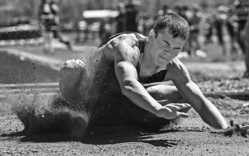 Timber Lake’s Carter Keller hits the sand after a leap in the long jump finals.