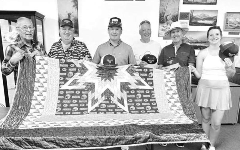 Pictured with Del Iron Cloud (left) who donated the Green Bay Packers star quilt are (l-r) Marty Biegler, Duffy Dupris, David Biegler, Leroy DuBray, Stacey Littler (and Josh Biegler). They all bought Kraft #85 caps for a chance to win the quilt. Buyers not pictured are Bart Biegler and Vallie Ross Pettersen. The winner of the quilt was Marlene Biegler, who won cap #10 with one of the $5 raffle tickets.