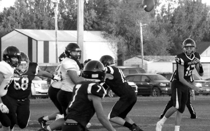 Timber Lake quarterback Kedrick Martin (12) passes to Slater Ducheneaux (7) while Sawyer Holzer (68) and Jayce Lawrence (19) block against the Faith Longhorns on Friday. Photo by Jon Flatland