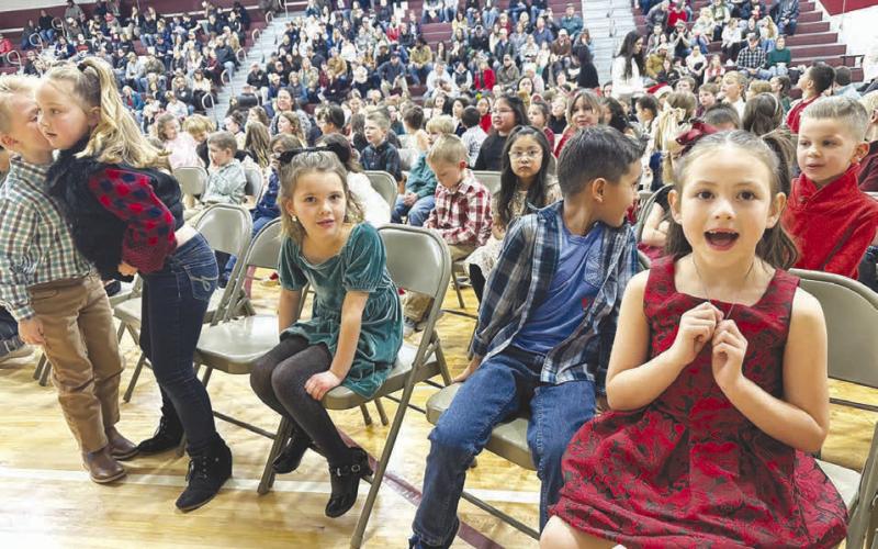 ANTICIPATION Kindergartners wait for their turn on stage at the Timber Lake Elementary Christmas Concert on December 4. Becket Rose (left) whispers to Lyllian Tesch while Harper O’Leary, Pieter Scholtz and Rylie Traversie make eye contact with the camera.