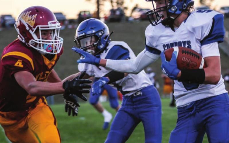 Lemmon-McIntosh’s Tanner Miller (5) reaches out to stiffarm Mott-Regent-New England’s Cole Manolovits while Riley Tennant (7) rushes in to block during their game Friday at Mott. Photos by Robert Slocun