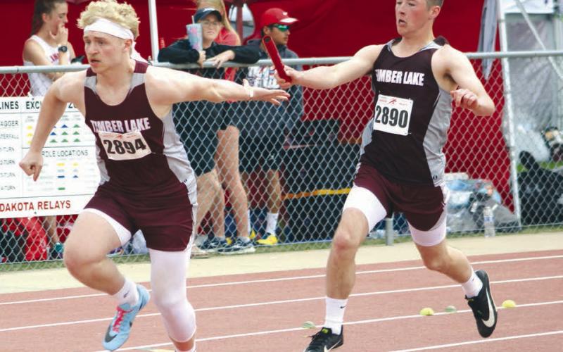 Timber Lake’s Averie Marshall, above, lands in the pit during long jump competition at the TL Last Chance Meet last Thursday, May 4. Marshall finished second in the event with a mark of 14-11.5. Right, Cole Ducheneaux reaches out to pass the baton to Brady Sandquist during the 400 meter relay. Rounding out the relay team for Timber Lake are Jayden Miller and Gavin Farlee. Photos by Jon Flatland &amp;amp; Mary Farlee
