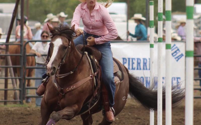 Above, CeCe Cowan of Eagle Butte puts her horse through the poles during Saturday competition at the State 4-H Finals Rodeo. Cowan went on to win the State Jr. Girls pole bending championship. Below, Kaydence Kennedy of Faith makes a successful run in the Jr. Girls Flag Race.