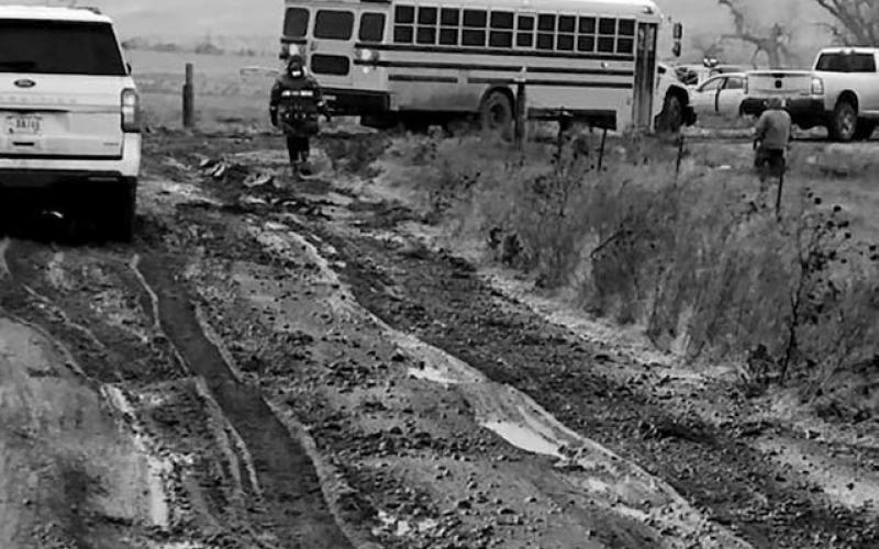 Volunteers had to be called in to push out a Takini School bus that became stuck on one of the nearly impassable roads in the Cottonwood area on Tuesday, Nov. 25. No students were on the bus at the time it became stuck. Schools across the area cancelled classes and activities on Tuesday due to dangerous travel conditions.
