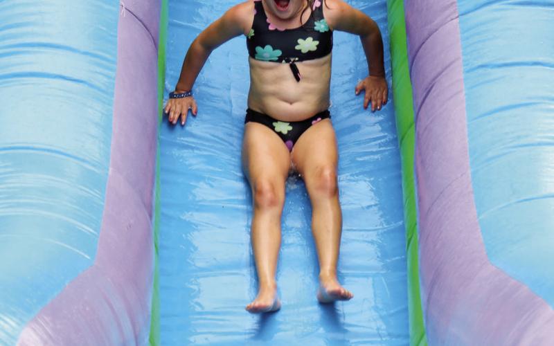 Clara Nilson, daughter of Kyle and Alision Nilson, screams as she goes down the giant water slide at the Timber Lake Fire Department’s annual 4th of July picnic last Friday. The water slide and other inflatables helped the kids beat the heat outside while the firemen served up traditional picnic food of burgers, hot dogs and watermelon in the Timber Lake Community Center. Photo by Jon Flatland