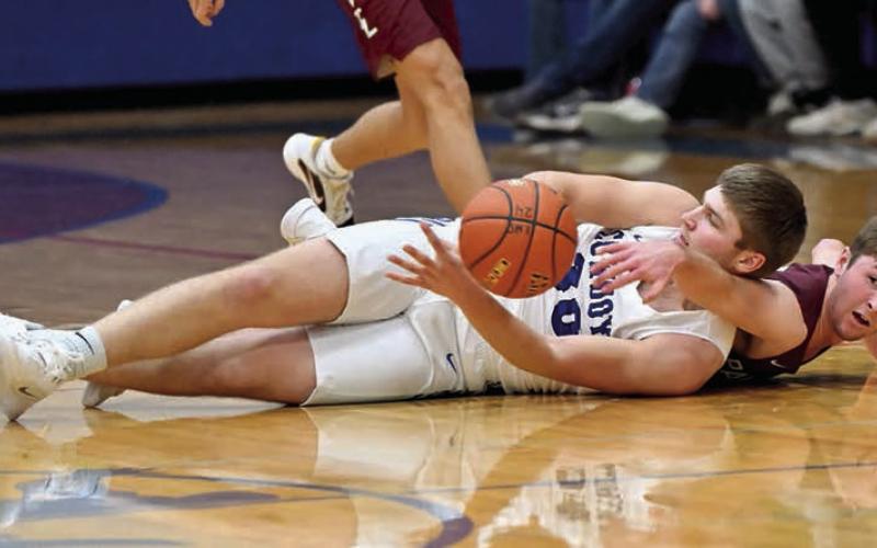 Timber Lake guard Cole Ducheneaux battles Lemmon’s Blair Ham (in white) for a loose ball during the boys basketball season opener between the two teams last Friday, Dec. 13, in Lemmon. Ham would later hit a game-winning 3-pointer with eight seconds remaining to give Lemmon a 64-62 win. Topic photo by Marie DuPreez