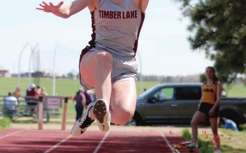 Timber Lake’s Carlie Lawrence takes to the air in a long jump attempt. Photo by Jon Flatland