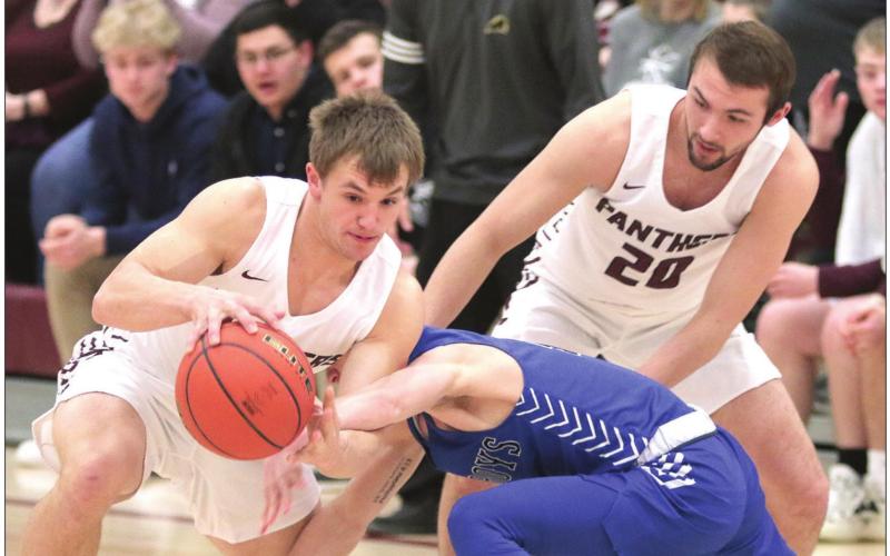 Ballhawks Seniors Hank Kraft (LEFT) and Brandt Ducheneaux releive a Lemmon Cowboy of his basketball during their Region 8B playoff basketball game. The Panthers upended Lemmon and advanced in the playoffs. Photos by Jon Flatland