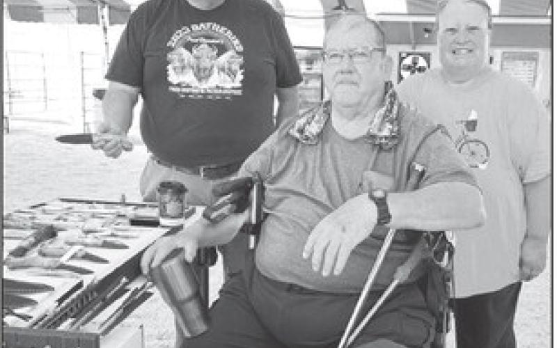 Art Rave of Isabel (left) inspected the knives and other creations that Mike and Dawn Stocklin of Faith showed at the Days of 1910 Vendor Fair.
