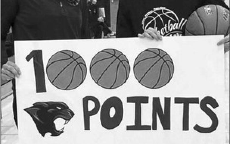 Timber Lake Coach Erin Gimbel (left) last Tuesday, Dec. 6, welcomed senior Carlie Lawrence into the 1,000 Career Point Club during the Lady Panthers girls basketball home opener against Tiospaye Topa. The daughter of Cody and Mary Lawrence, she actually reached the milestone in the final game of last season during the Region 8B Tournament but school officials waited to recognize the achievement in front of a hometown crowd to open this season. Courtesy Photo