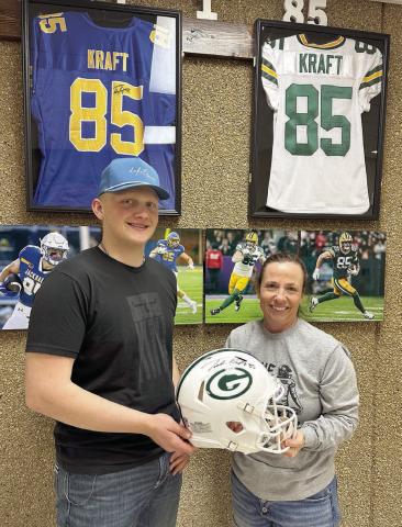 Mae Keller (RIGHT) took home the Green Bay Packers helmet autographed by Tucker Kraft with a bid of $20,000 at the benefit for Braylen Hansen (left), a senior at Timber Lake High School, held March 13. (More inside) Photo by Kathy Nelson