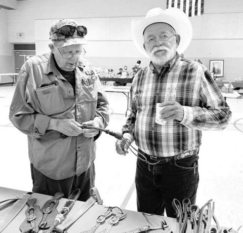 Sea of Grass artists James Pollock (left) of Pierre and Mick Harrison of Belle Fourche check out some leather work by Don and Unalee Howe of Dupree (pictured below). Unalee was director of the Sea of Grass art project in 2015.