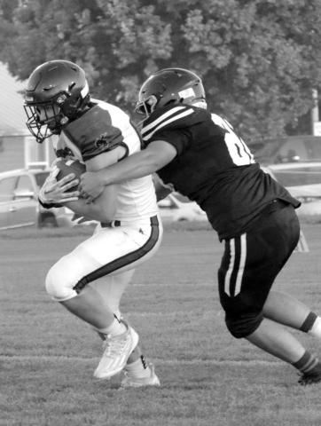 Senior lineman Dan Peterson wraps up a Lemmon-McIntosh runner during his return to the field last Friday after missing all of last season with an injury and immediately made his impact felt on both sides of the ball, protecting quarterback Gracen Hansen on offense and collecting four tackles and three assists, including two stops for lost yardage, on defense. Photo by Jon Flatland