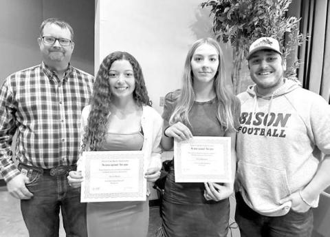 Rusty Gebhardt (left) and Shaun Maher (right)of the Timber Lake Rodeo Assn. awarded $1,000 scholarships to Arianna Bieber (left) and Gailup Bollinger (right). Both girls have been dedicated volunteers at the Rodeo Association’s Days of 1910 Celebration.