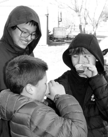 Dupree seventh graders Dean Longbrake and Kyle Lawrence samples the fresh buffalo blood while their classmate Lawrence Young observes them.
