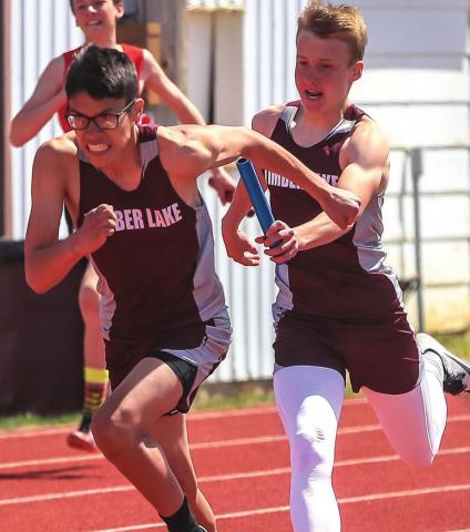 Otto Red Bear has determination on his face as he takes the handoff from Gracen Hansen during their 4x200 relay race at last week’s last chance meet.