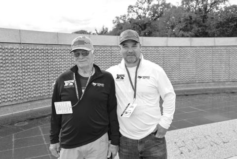 Carl Winterberg (left) and his son Adrian (right) at the center of the World War II memorial, where each gold star represents 100 deaths that occurred during the conflict.