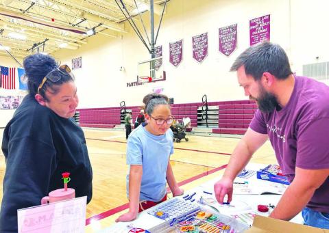 Sophia Ley and her aunt, Colette Brown Otter, visit Walker Rose’s table to see what they can learn.