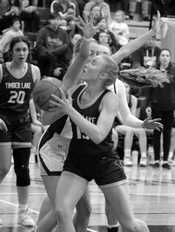 Junior forward Kendyl Locken is fouled by a Castlewood player on a move to the hoop during Timber Lake’s battle with Castlewood in the SoDak 16 Tournament last Thursday, March 2. Looking on is Jasmine Nash (20). Photo by Jon Flatland