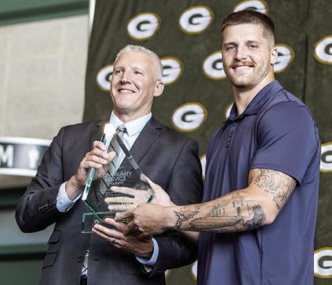 Green Bay Packers tight end Tucker Kraft, a native of Timber Lake, was presented the Packers 2025 Community Service Award last Friday, Aug. 22. Presenting the award was Ryan Krumrie, a partner at Hager, Dewick &amp; Zuengler, S.C. and Chairman of the Greater Green Bay Chamber of Commerce. Photo by Madison Morris courtesy of Green Bay Packers.