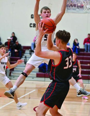 Timber Lake junior forward Holden Gill (5) leaps while attempting to block an outlet pass by Potter County’s Jonah Pribyl (33) last Friday, Feb. 28. The Panthers won a nail-biter and are playing in the Region 8B Tournament this week. Photo by Marie DuPreez