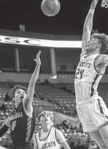 McLaughlin’s Evan Archambault tries to float a shot over the defense of Custer’s 6’5” center Gage Tennyson during the Lakota Nation Invitational. Photo by Robert Slocum
