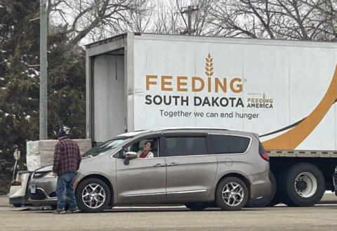 A Feeding South Dakota volunteer interacts with a food recipient at the organization’s March food distribution on Main Street of Isabel. Photo by Jon Flatland