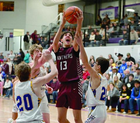Panther forward Jackson Bigger (13) drives to the hoop between a pair of Wessington Springs defenders during the SoDak 16 matchup between Timber Lake and the Spartans. Photo by Marie DuPreez