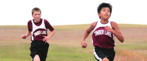 Demetrius Sanchez and Thomas Holzer race in their home cross country meet.