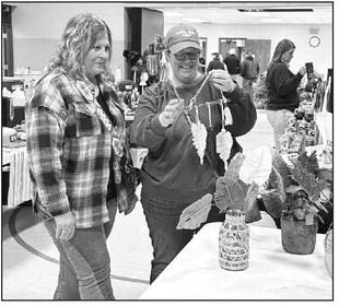 Nancy Olson of McIntosh, left, shows a piece of macrame from her vendor table to Julie Marshall of Timber Lake at the Timber Lake Holiday Craft Fair held Saturday, Nov. 2, at the Timber Lake Community Center.