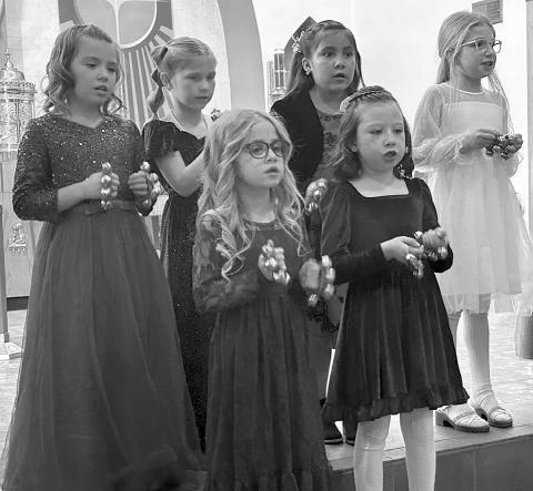 The K4J Choir from Holy Cross Church sang “Come and Rejoice” and “Silent Night,” accompanied by Cheryl Lawrence. FRONT: Elsie Maher, Bexley Dupris; BACK: Brie Parker, Tessa O’Leary, Molly Dupris, and Rose Maher.