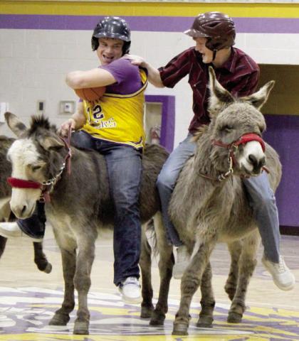 Dupree School player Roper Eaton (left) tries to protect the ball as Cruz Birkeland, playing for the Farmers &amp; Ranchers team, attempts to steal it while staying atop his donkey during Donkey Basketball sponsored by the Dupree Booster Club last Thursday, Jan 23. Photo by Patty Peacock