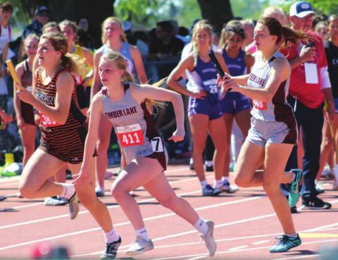 ABOVE: Shay Kraft hands the baton to Averie Marshall in the girls 400 meter relay state finals, in which the team, including Maci Maher and Kiya Mowrer, broke the school record. Photo courtesy of SD Public Broadcasting